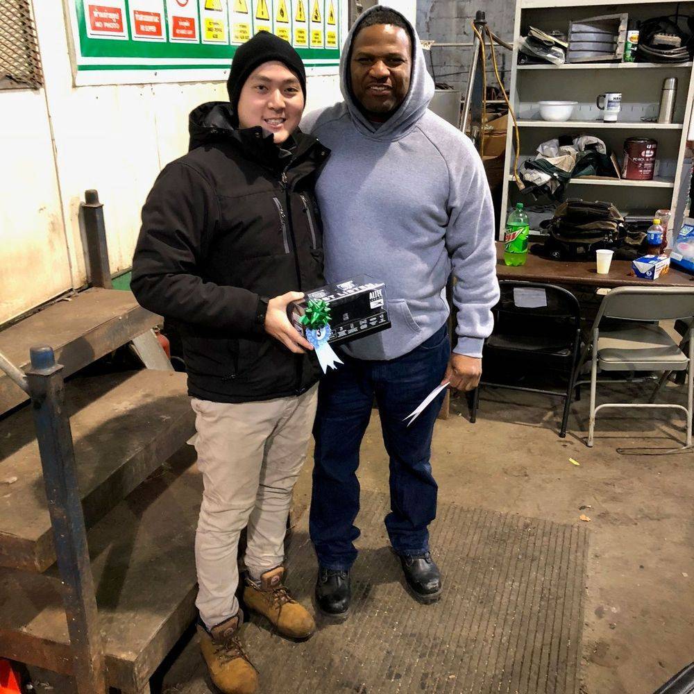 Two people standing at the counter inside the warehouse, one holding a small item.
