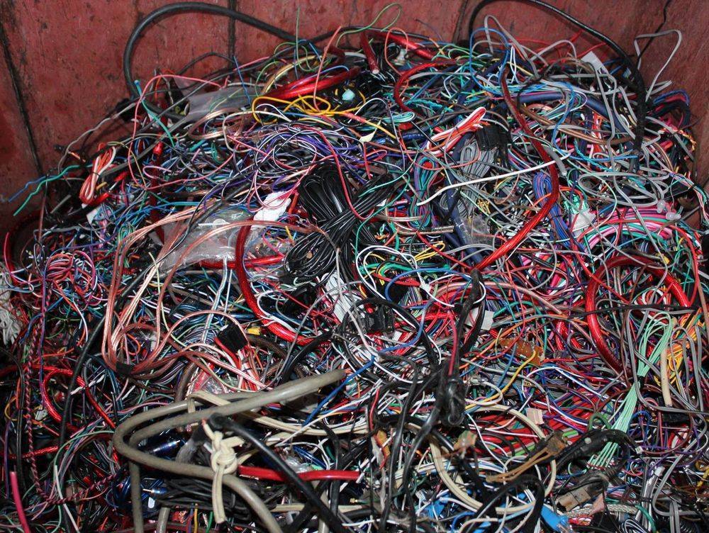 Tangle of insulated copper wire in a bin.